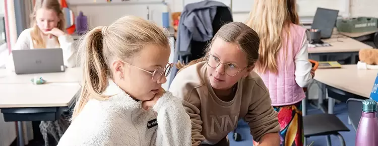 2 meisjes helpen elkaar met hun schoolwerk