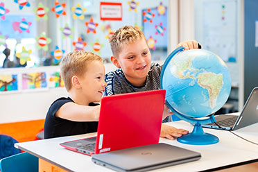 Kinderen leren samen met laptop en globe 